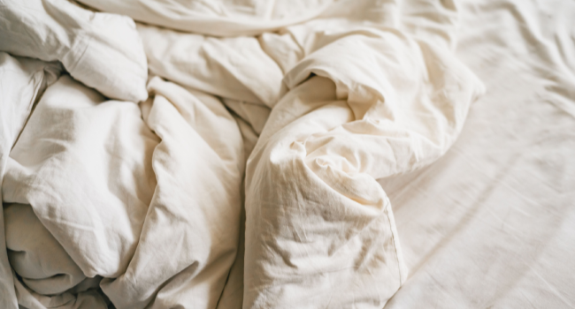 Couette hôtel blanche moelleuse sur un lit soigneusement fait en chambre professionnelle