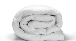couettes hôtel professionnelles blanches disposées sur lit d'établissement haut de gamme