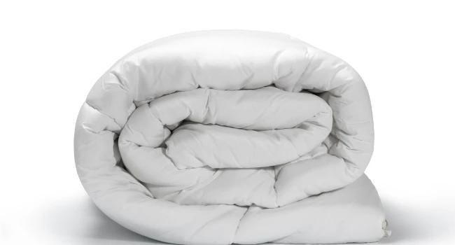 couettes hôtel professionnelles blanches disposées sur lit d'établissement haut de gamme