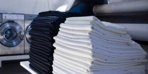 Gestion du lavage linge de lit hôtel avec draps blancs professionnels empilés