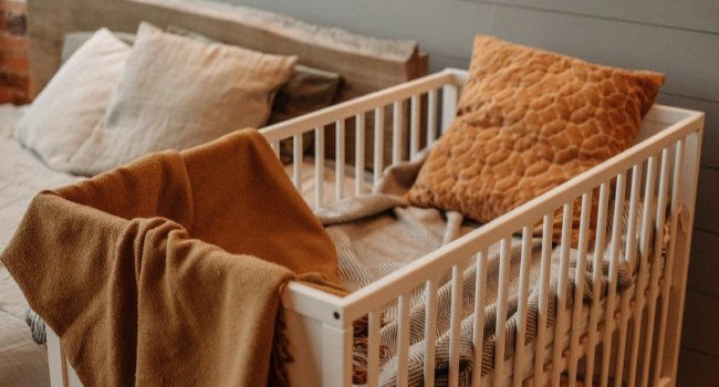 Lit bébé hôtel positionné dans une chambre familiale, prêt pour l'accueil des jeunes enfants