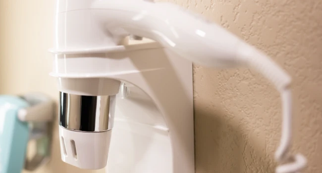 sèche-cheveux hôtel professionnel fixé au mur d'une salle de bain moderne équipée