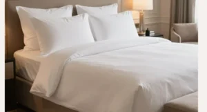 Linge de lit hôtel en coton blanc soigneusement dressé sur un lit professionnel
