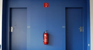 extincteur et signalétique de sécurité incendie dans un couloir d'hôtel professionnel